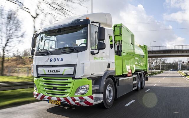 Een vuilniswagen onderweg onder een viaduct