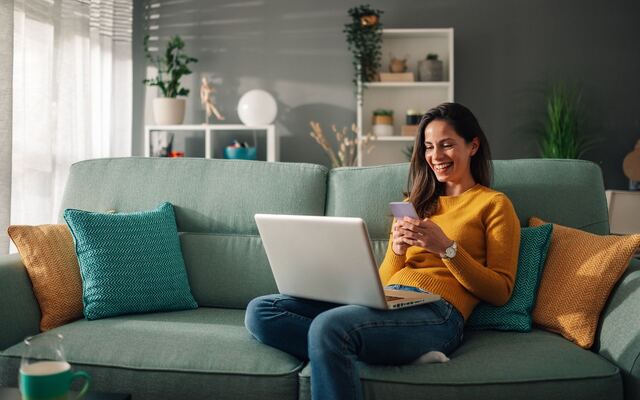 Iemand regelt het ophalen vanaf de bank met laptop en telefoon