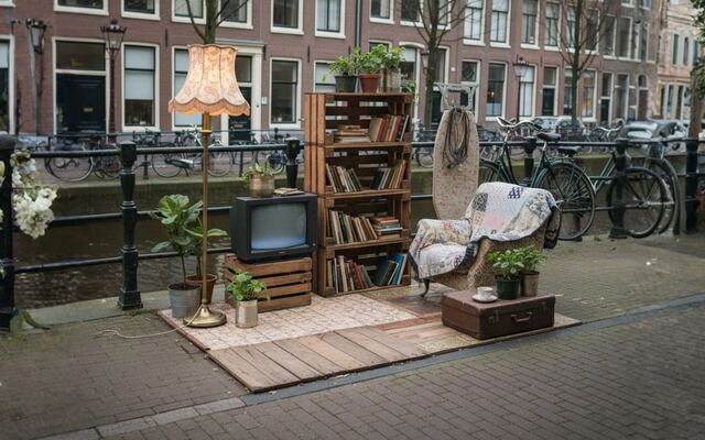 Een kast, een stoel en een televisie op straat langs een gracht