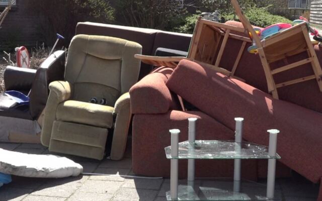 Een stapel afgedankte fauteuils en tafels op elkaar